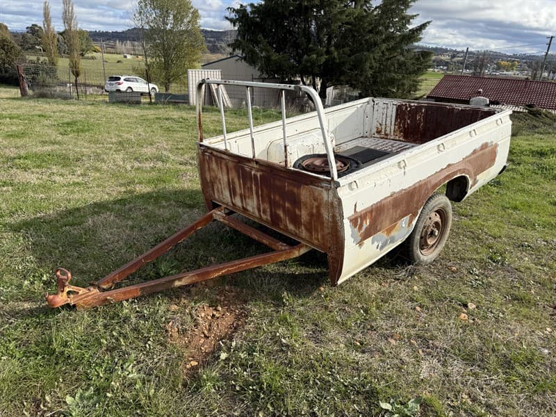 CUSTOM Nissan Utility back single axle trailer 7.6ft x 5ft, 14 inch tyres. No identifiers sighted, unregistered. Suit farm use. Located Bath…